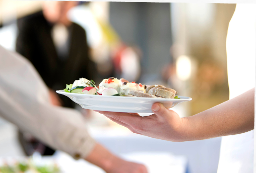 Waiter passing a plate at a catered event