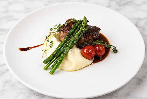 Professionally plated steak and vegetables
