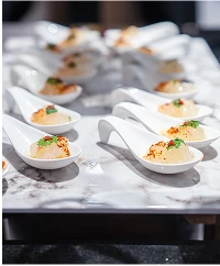Waitstaff carrying plated canapes