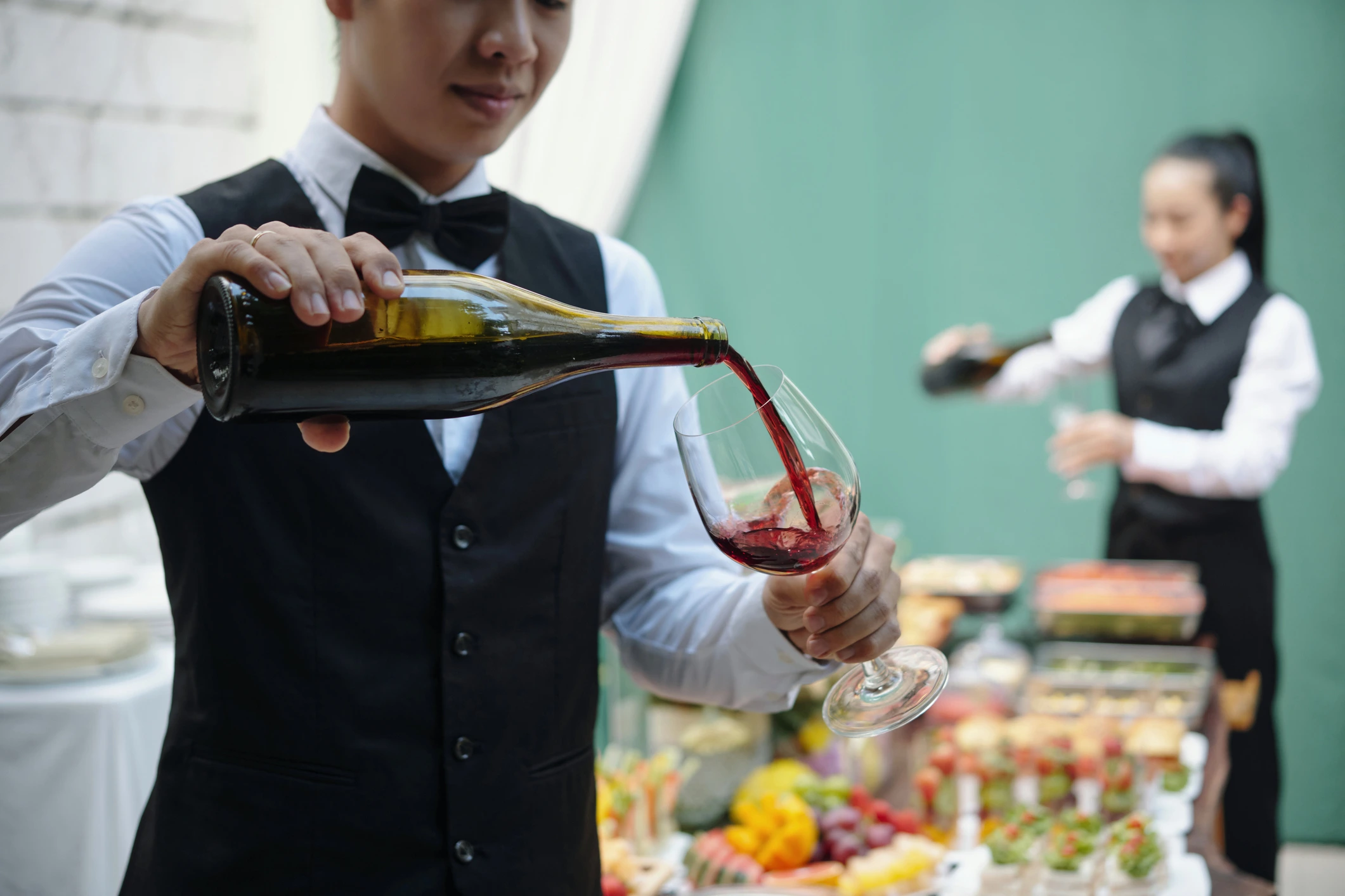 Waiter pouring wine during catered service