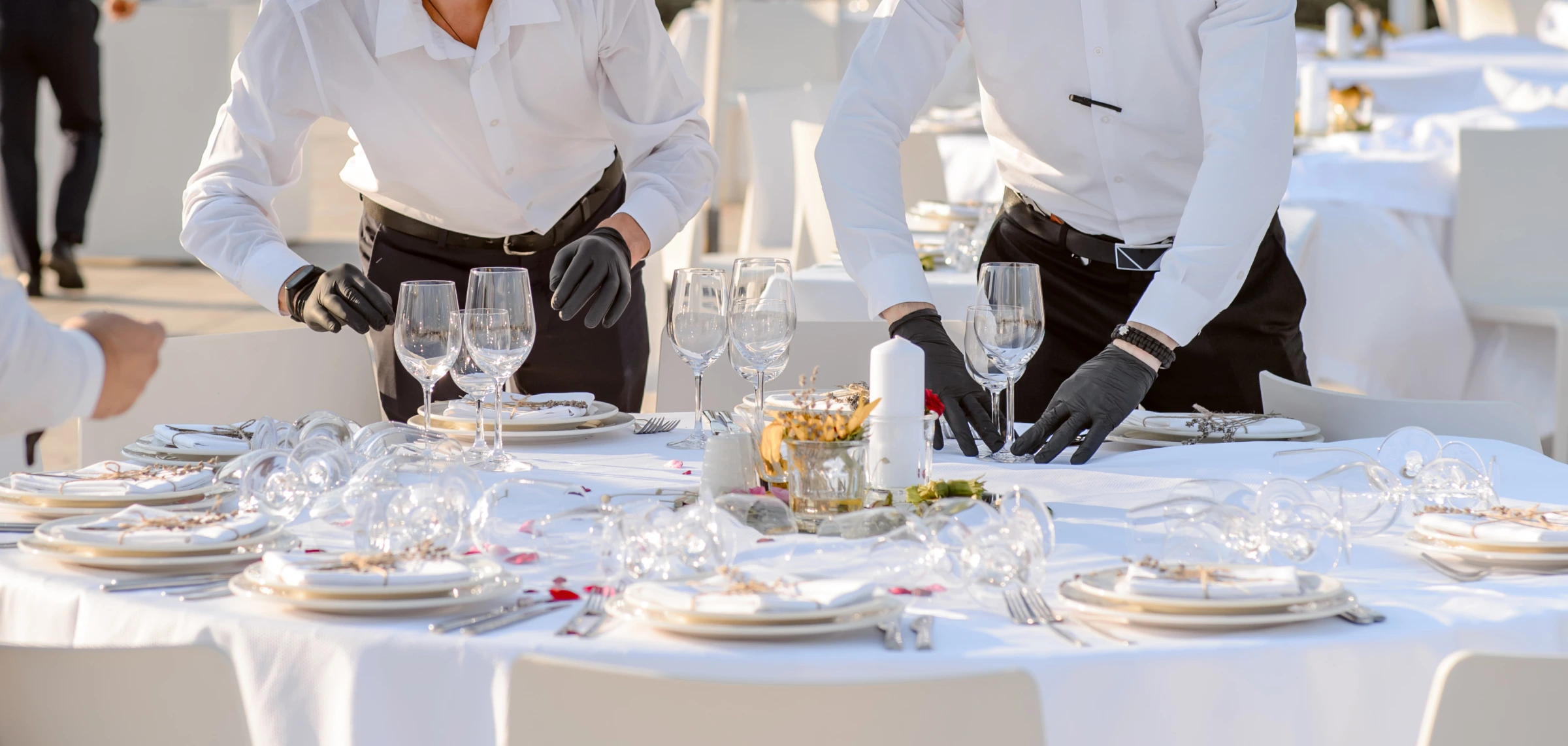 Professional waitstaff setting a corporate dining table